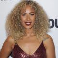 leona lewis with medium-length golden blonde curly hair with piece-y fringe wearing a red glitter dress
