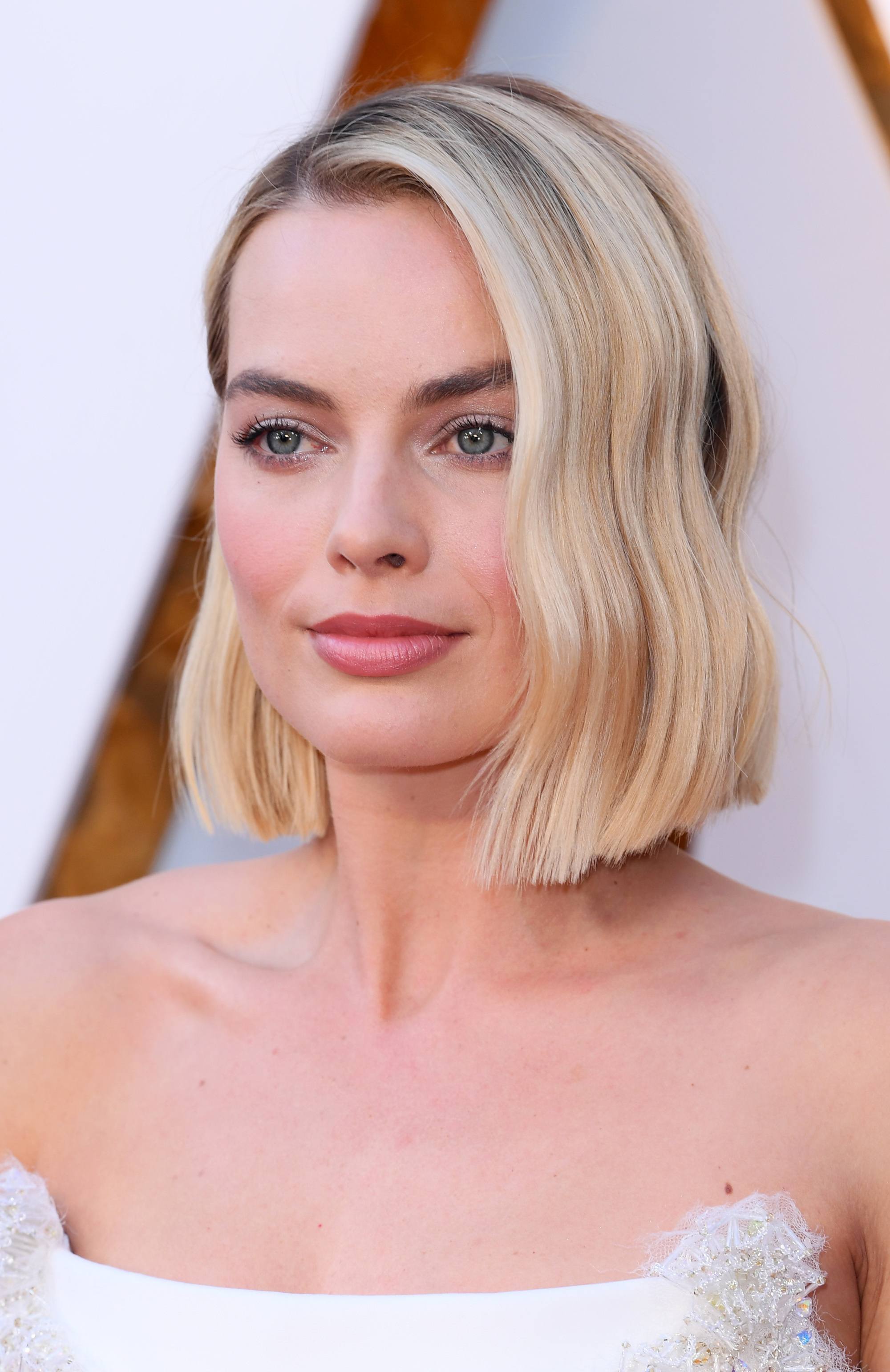 margot robbie wears popular short hairstyle blunt wavy blonde bob at oscars 2018 with strapless white dress