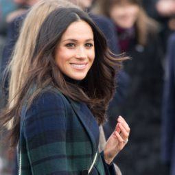 texturising hair products guide: close up shot of meghan markle with tousled hair, wearing green and black jacket and posing outside