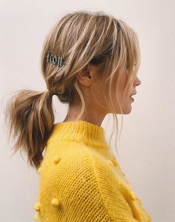 Second day hair: Laura Whitmore with blonde highlighted hair in a low ponytail with jewelled hair clip wearing a yellow jumper.