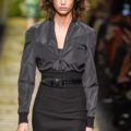 mica arganaraz with shoulder-length curly brown hair with bangs on runway wearing an all black outfit