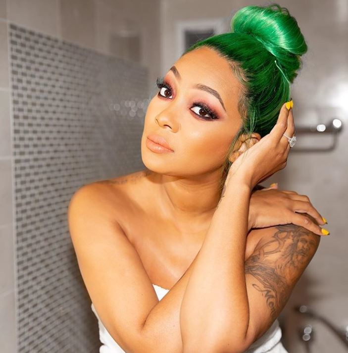 Green hair: Singer Monica Brown touching her bright green hair in bun updo.