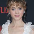 natalie dyer with blonde highlight curly hair with bangs in an updo at stranger things premiere