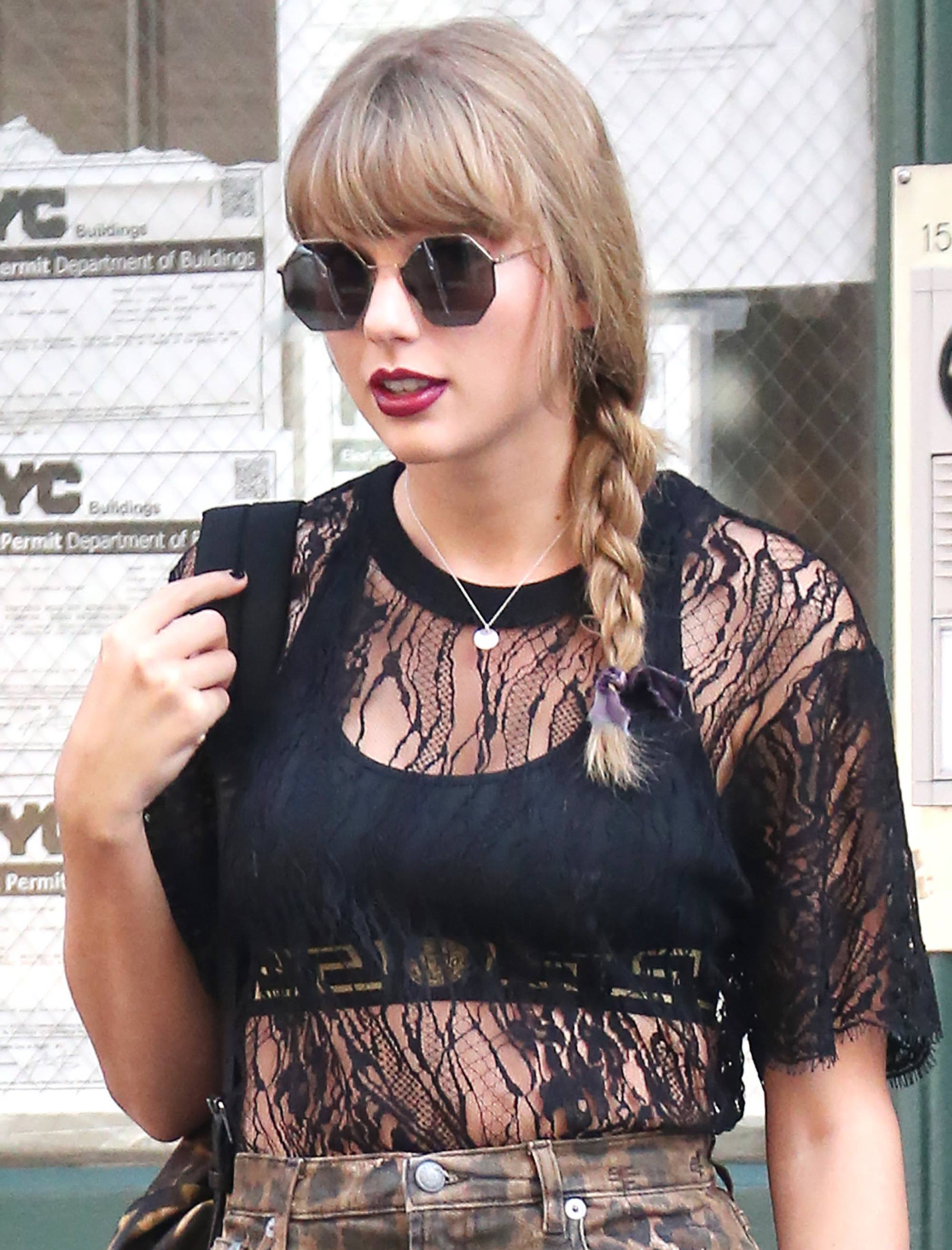 Side braid hairstyles: Taylor Swift with blonde medium length hair with a side braid and fringe wearing sunglasses and a black lace top.