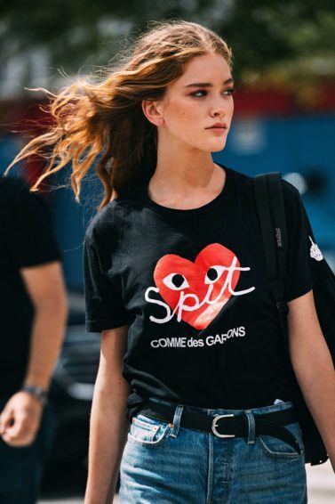 Thickening conditioner: Close-up shot of woman with thick, tousled brown hair wearing black top and jeans on the street, during A/W fashion week