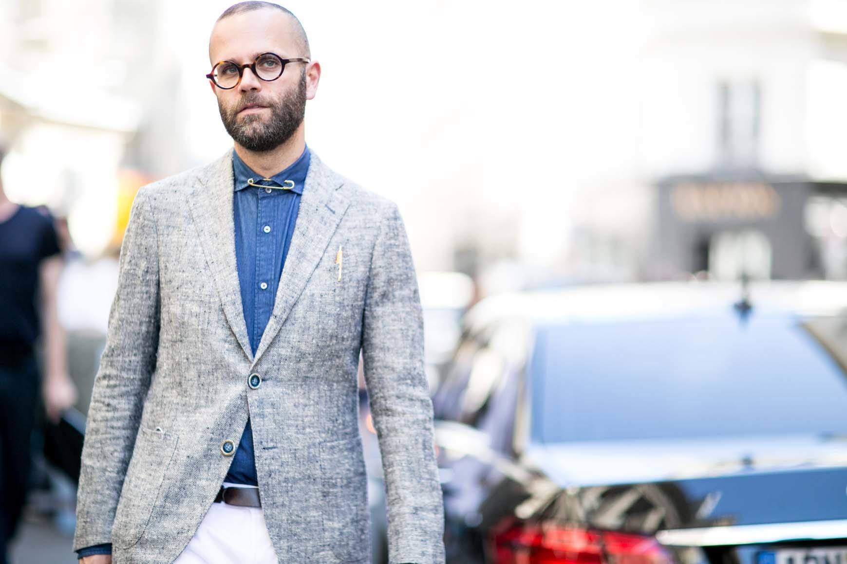 Man with bald head and glasses outside