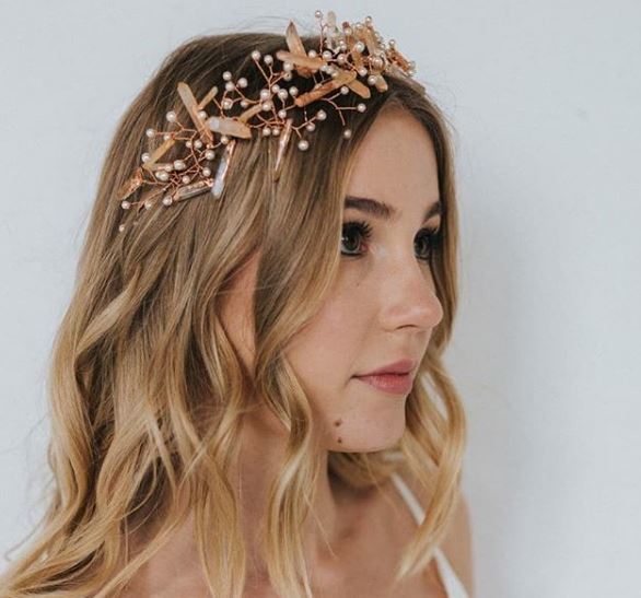 side view of a woman with blonde balayage hair with loose beach wavy hair and a crystal pearl headband