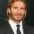 david beckham on the red carpet in a tux with slick long hair