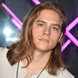 actor dylan sprouse with shoulder length layered dark blonde surfer hair