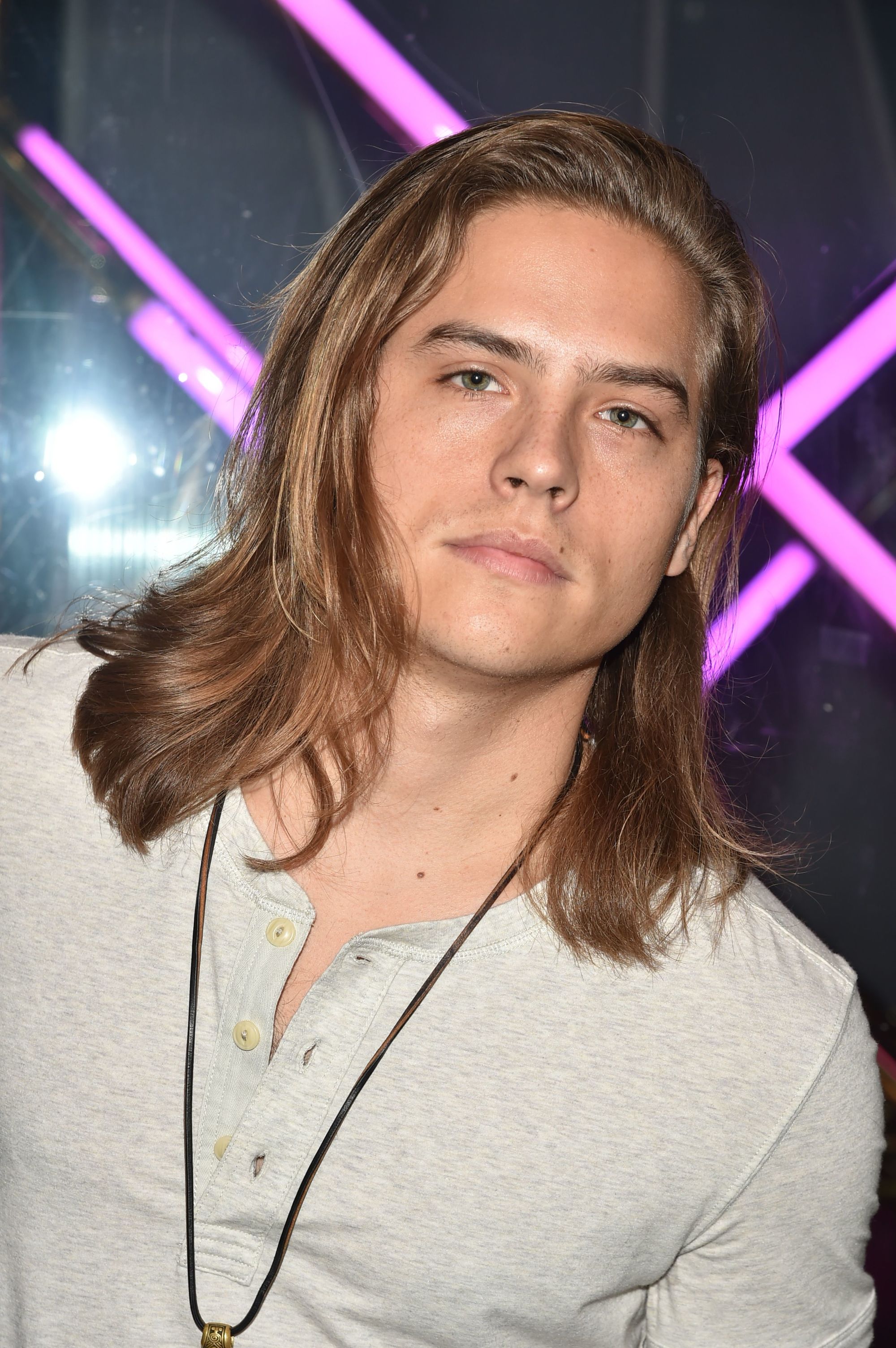 actor dylan sprouse with shoulder length layered dark blonde surfer hair