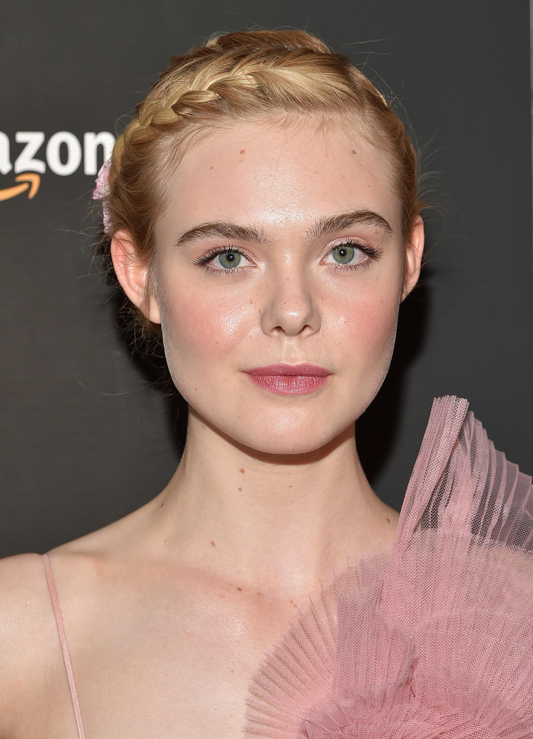 Growing out bangs: Elle Fanning with blonde hair in updo with headband braid wearing light pink tulle dress.