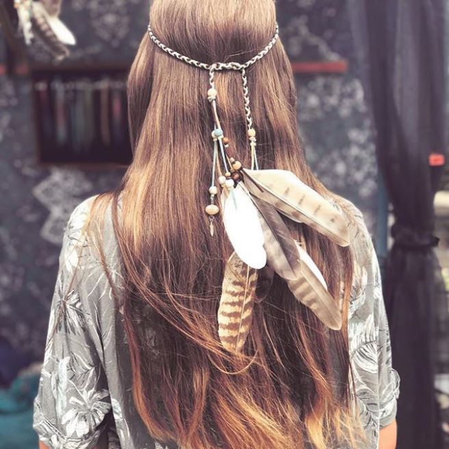 back view of long straight brown hair with hippie inspired headband with dangling feathers