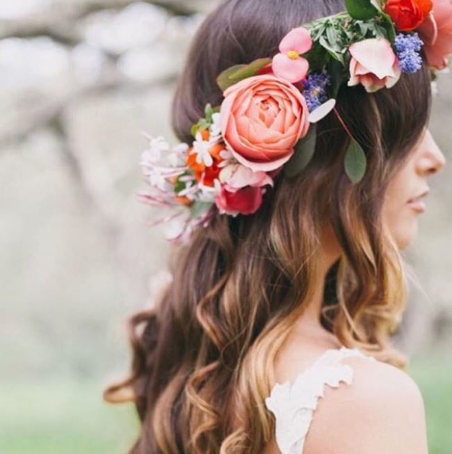 side view of woman with brown wavy hippie hairstyle with flower crown wearing white lace sleeveless dress