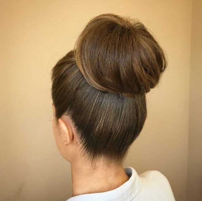 back view of woman with brown hair in high wrapped bun