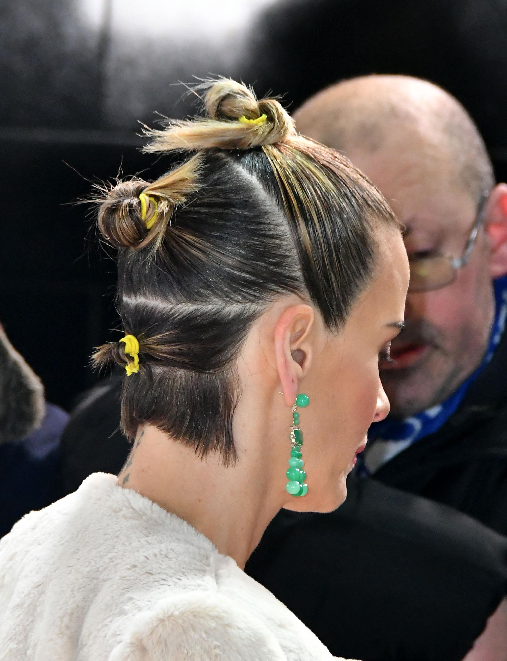 2019 hair accessories: Sarah Paulson with triple buns with neon hairbands, wearing a green earring and posing on the red carpet