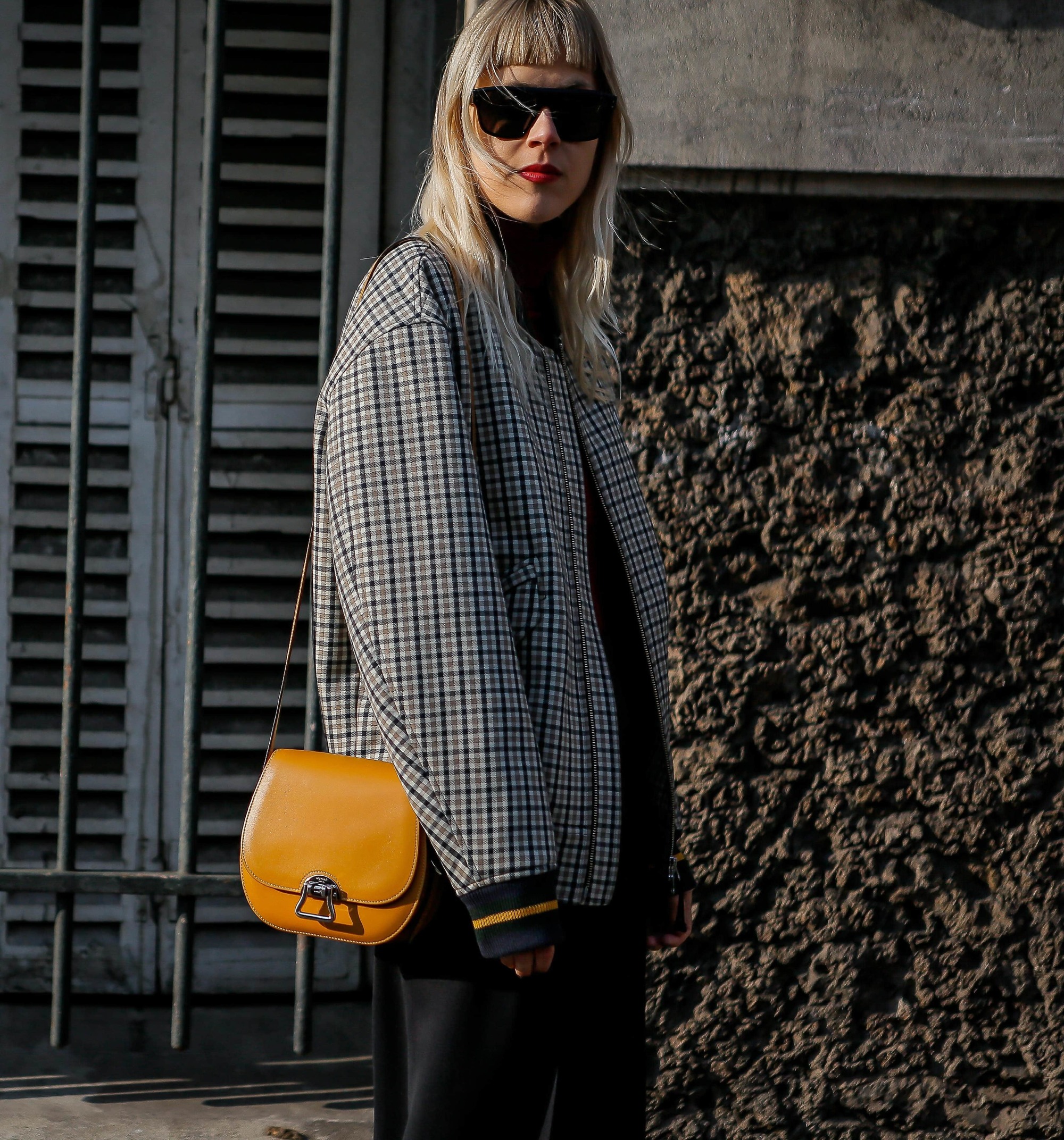 Grown out bangs: Street style woman with fine medium length ash blonde hair with blunt bangs.