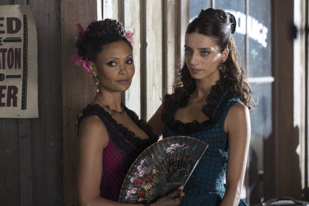 close up shot westworld characters maeve and clementine with a braided updo and half updo hairstyle, wearing costume dresses on set