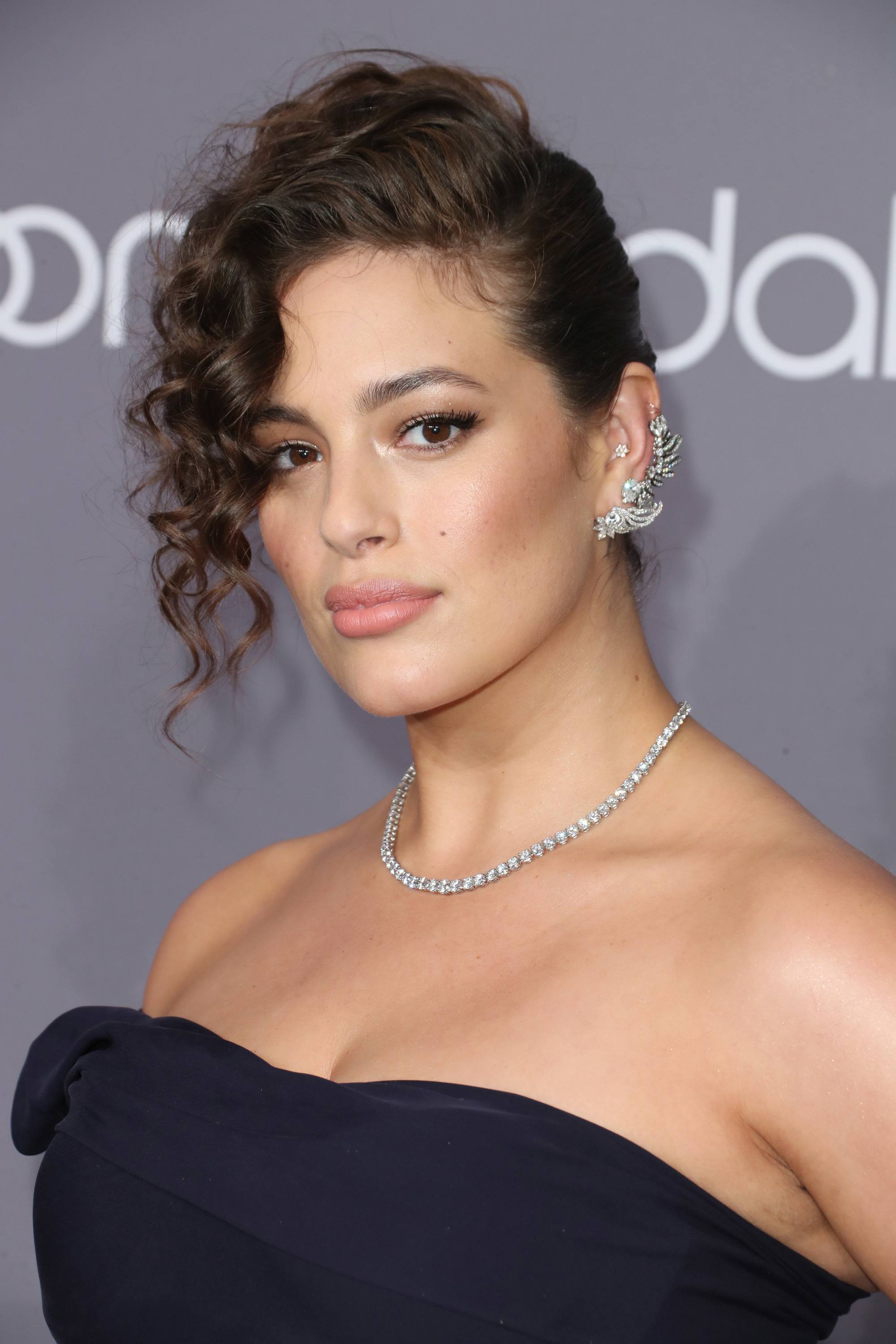 ashley graham with curly '80s inspired sweeping updo on brown hair
