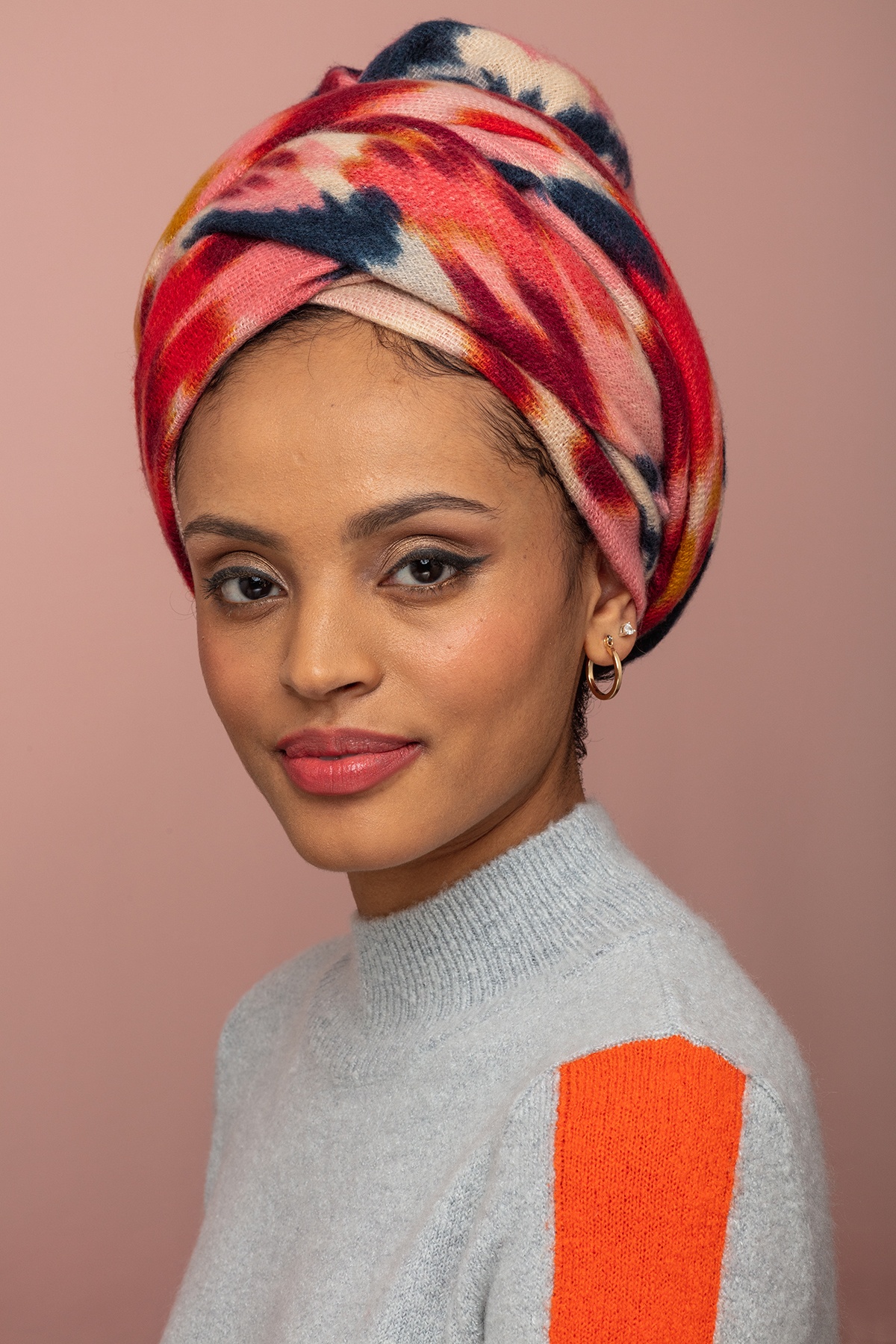 How to wear a headwrap: Woman with pattern headwrap styled in regal style.