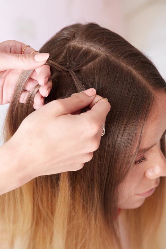 heart braid tutorial: close up shot of a model getting a dutch braid done by her friend