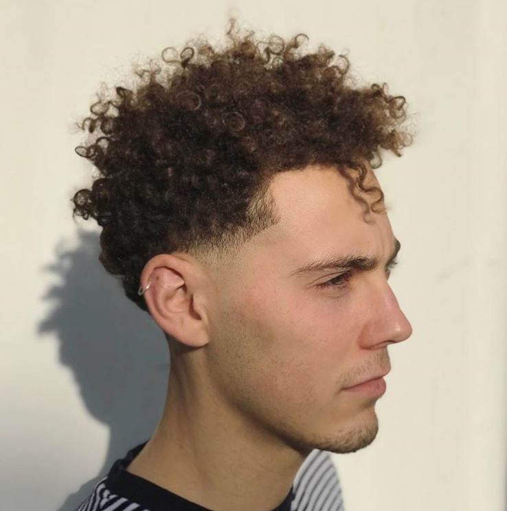 side view of man with naturally curly hair undercut