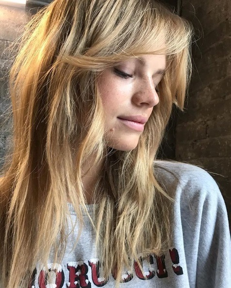 close up of a blonde woman with a wispy fringe and shoulder length hair