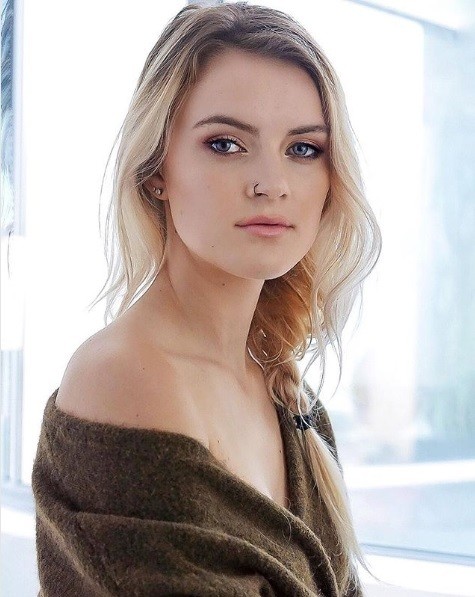 photo of a blonde woman with her long hair in a loose side braid with wispy loose strands