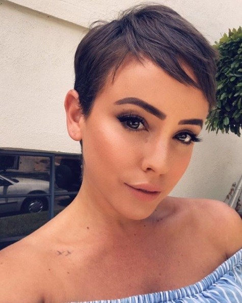 woman with a brunette pixie cut with wispy sideswept layers