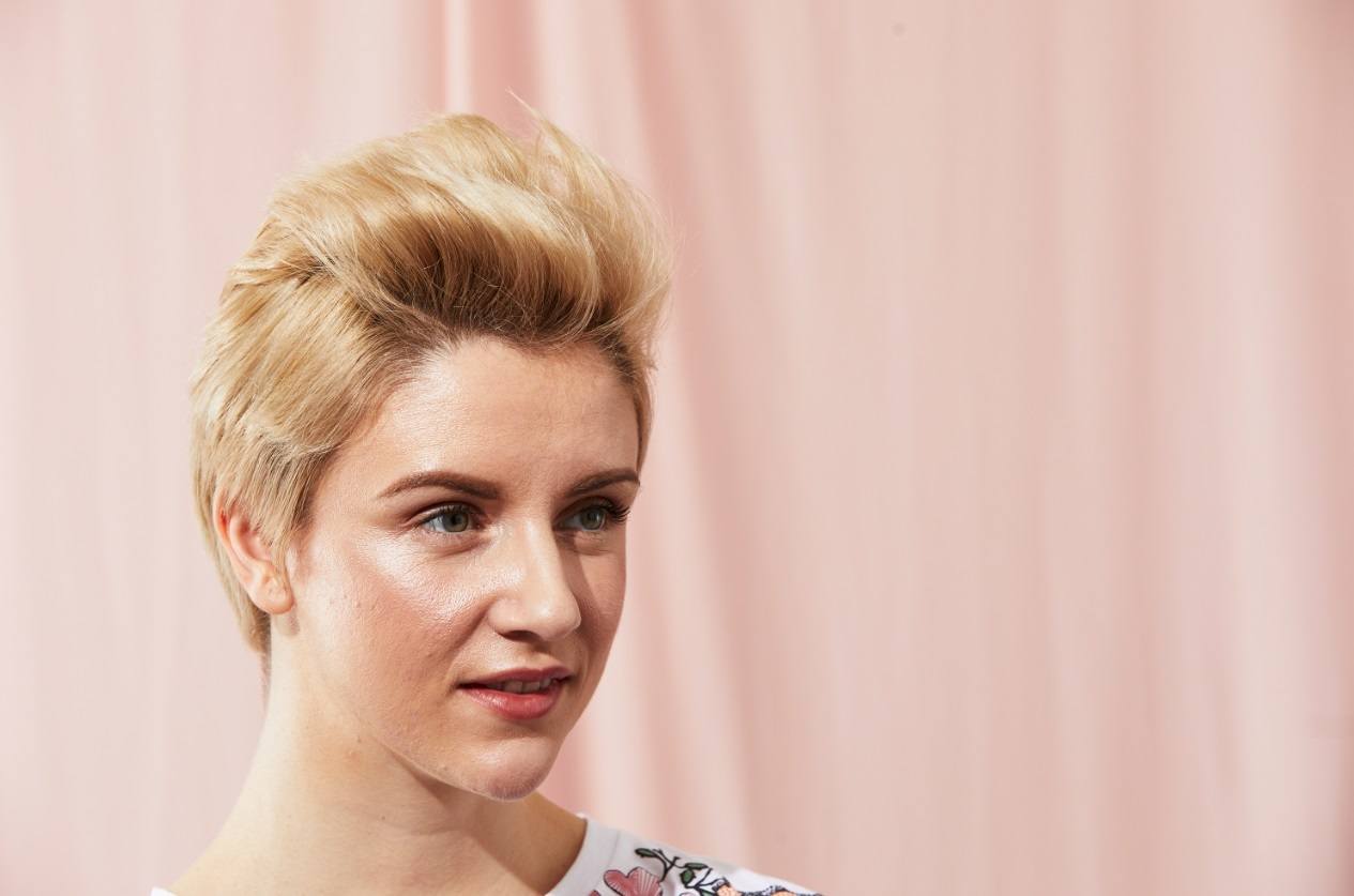 Blonde model with a pixie cut styled in a mohawk quiff
