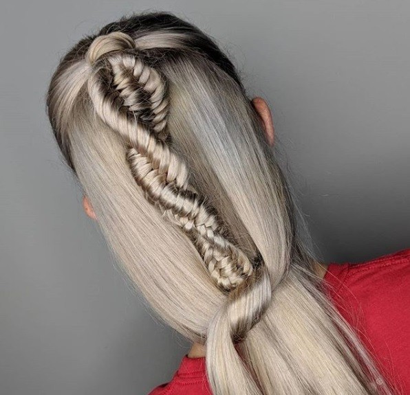 Back view of a woman with ash blonde/grey long straight hair in a half-up half-down DNA braid.