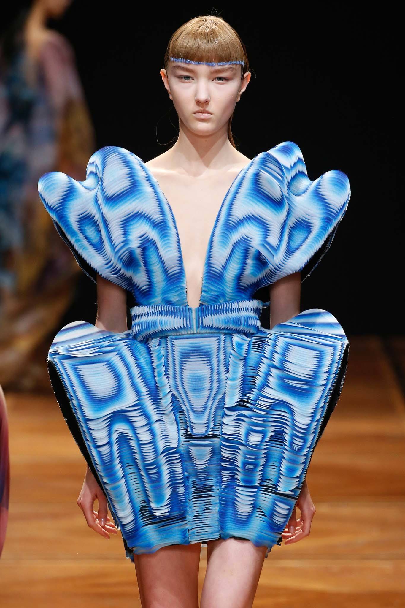 Haute Couture: Model on Iris Van Herpen runway with blunt fringe with small dip dye colour wearing a bold blue structured dress.