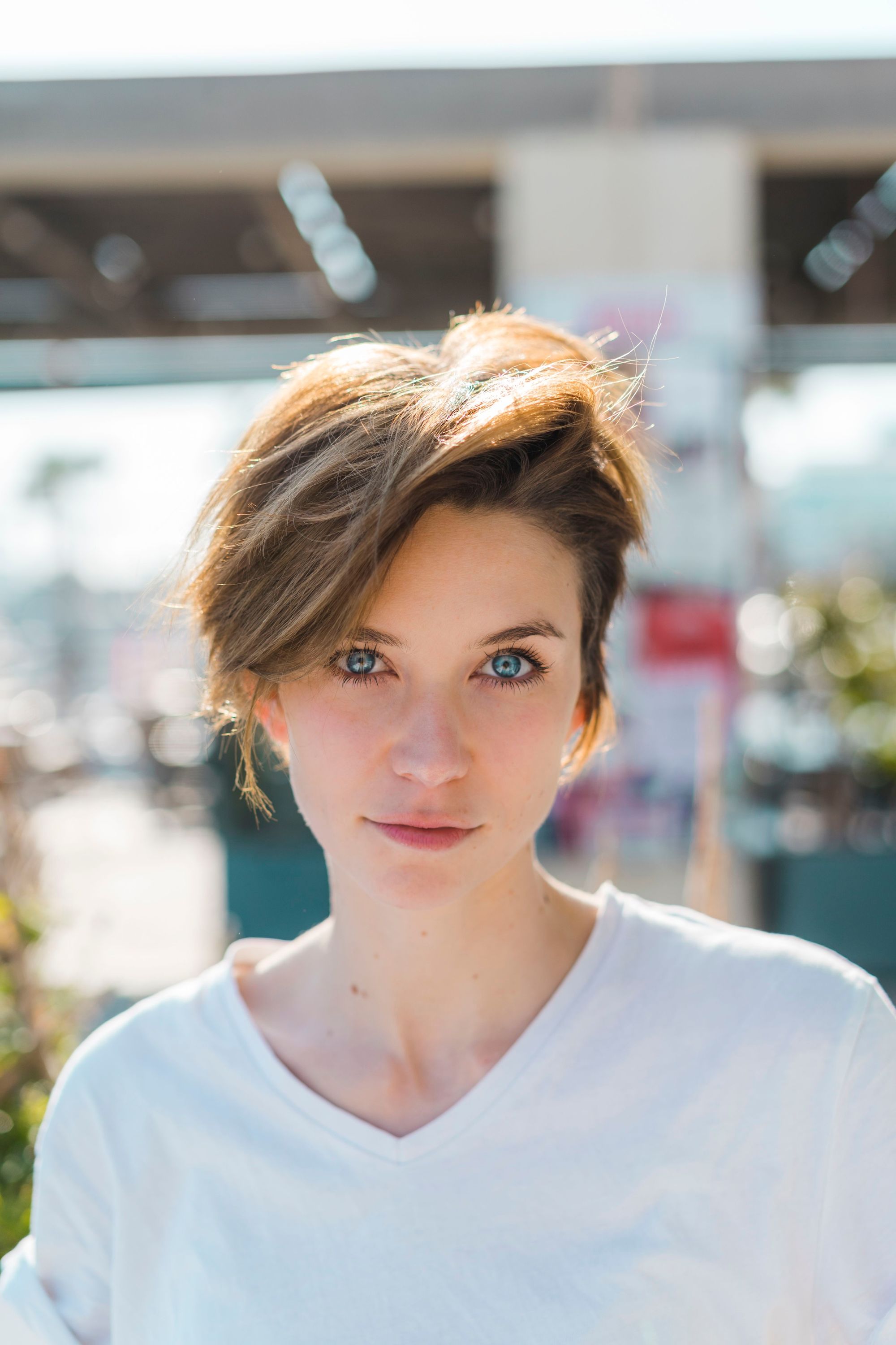 Haircuts for thick hair: Close up photo of a brunette woman with short pixie cut hair with sweeping layers