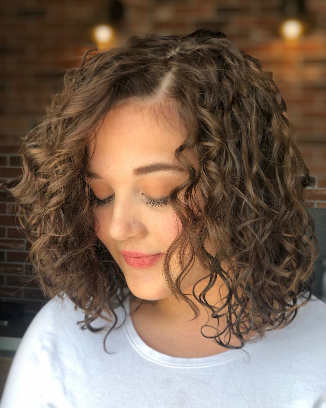 Brunette woman with a curly permed bob