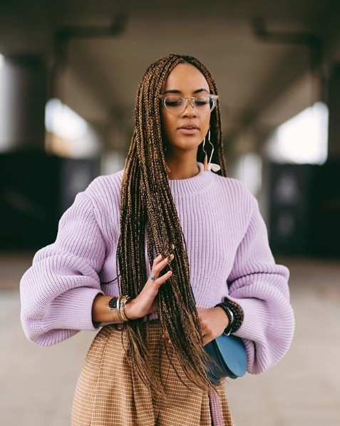 Long box braids: Woman with extra long brunette box braids, wearing a lilac jumper and glasses