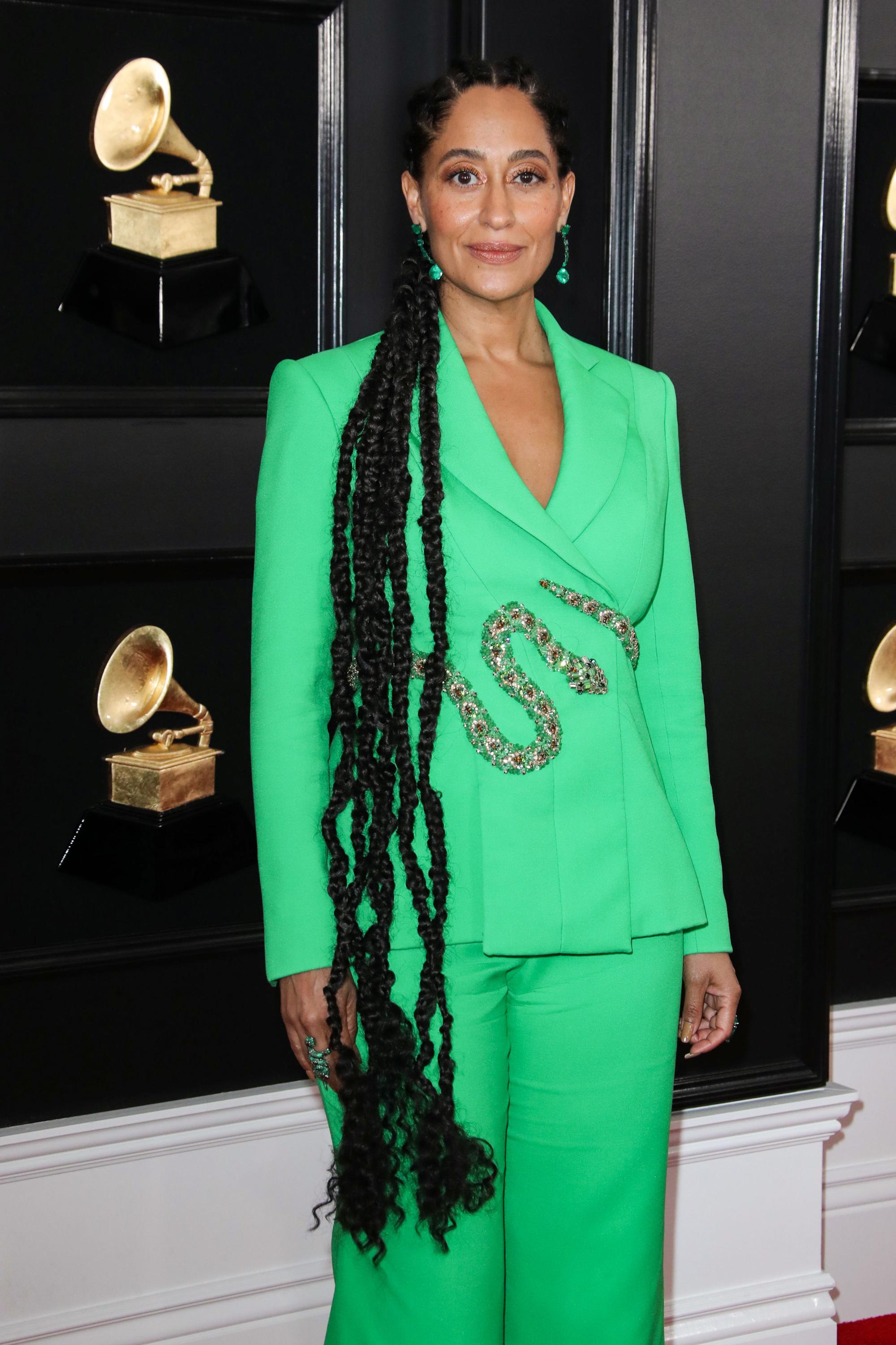 Red carpet hairstyles: Tracee Ellis Ross with very long braided hair wearing a green suit and snake belt at the Grammy Awards 2019 red carpet.