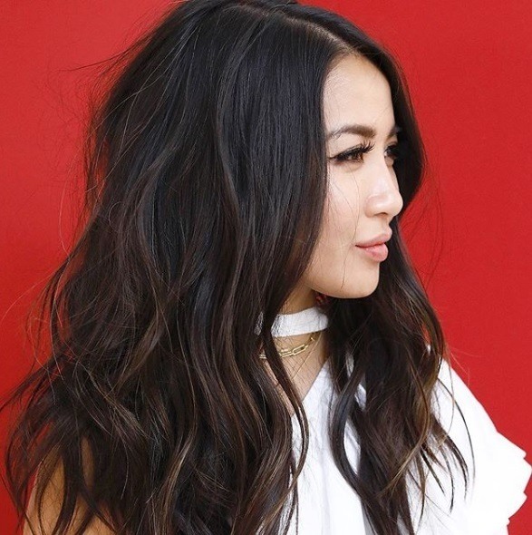 Long shag haircut: Close up shot of a woman with long dark chocolate layered hair