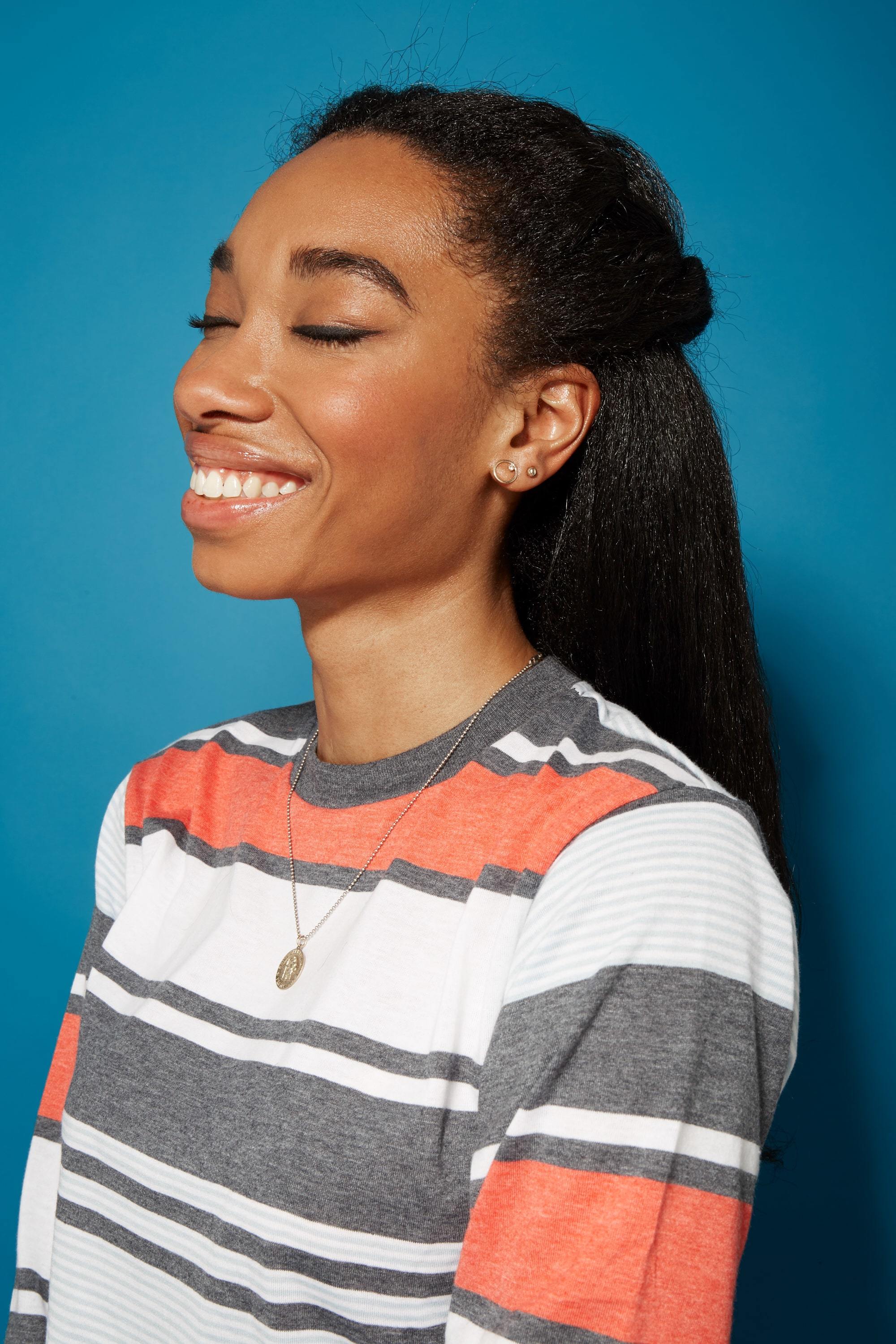 Blow out natural hair: Smiling woman with straightened natural hair in a half-up half-down hairstyle