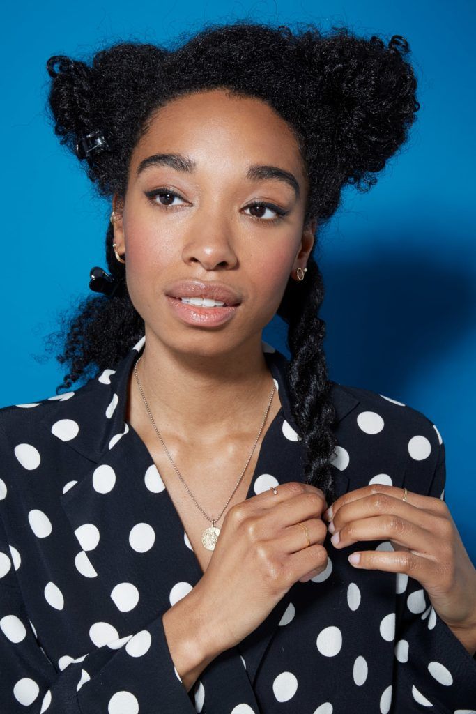 Blow out natural hair: Natural haired woman with her hair in sections, rope twisting a lower section of hair.