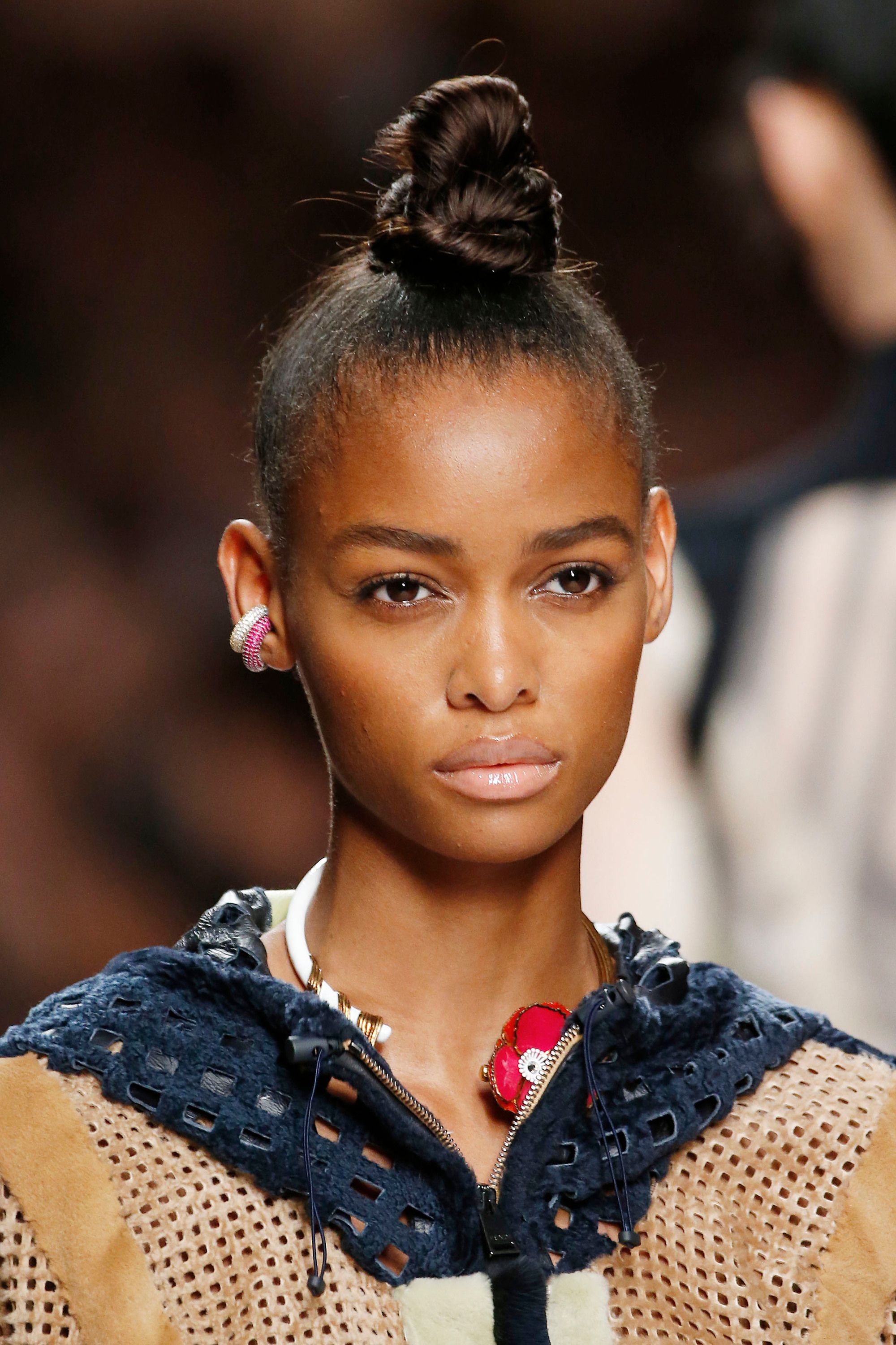 Knot bun hairstyle: Runway picture of a woman with a tight slicked back ninja bun top knot hairstyle