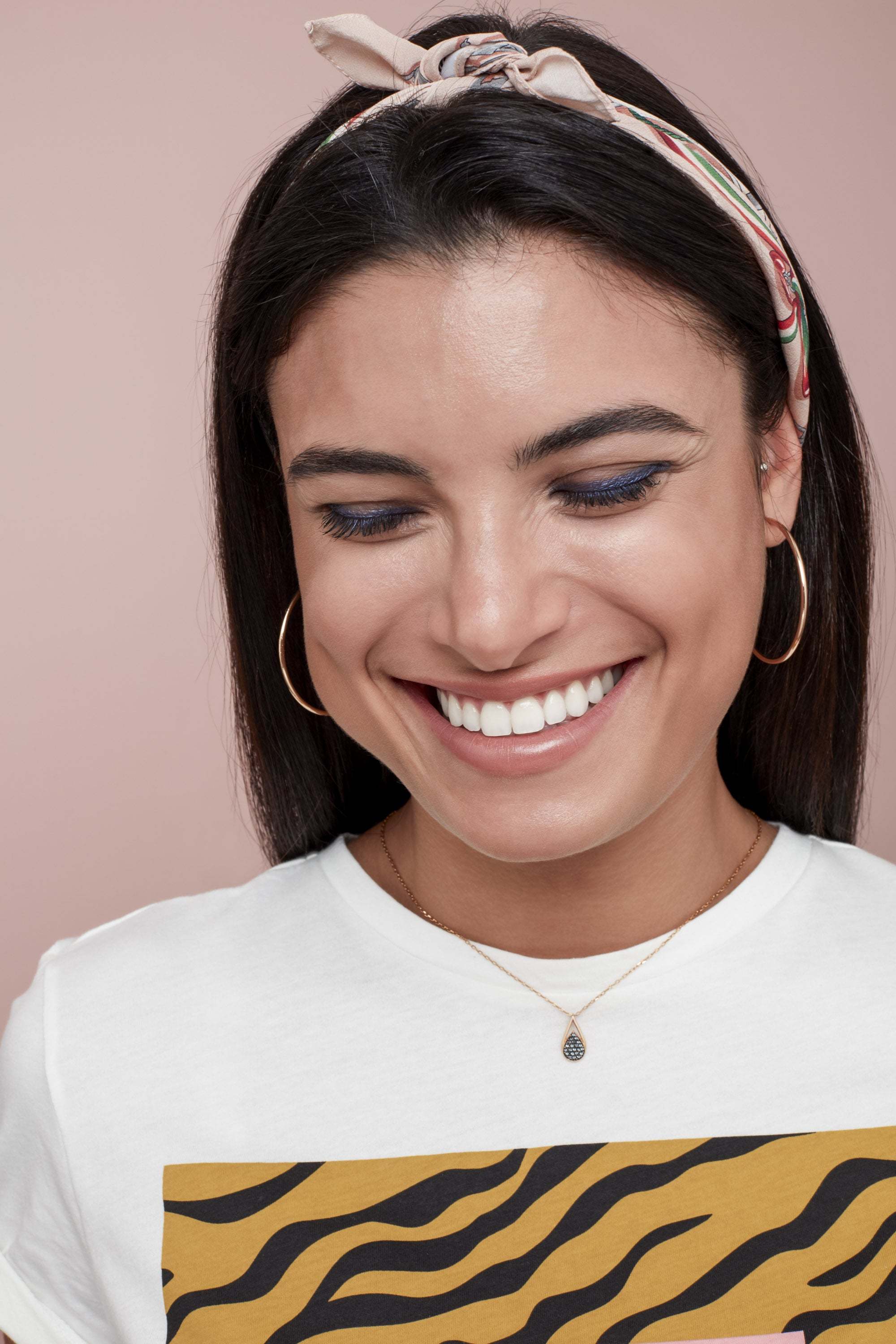 Woman with sleek hair with a bandana wrapped around it