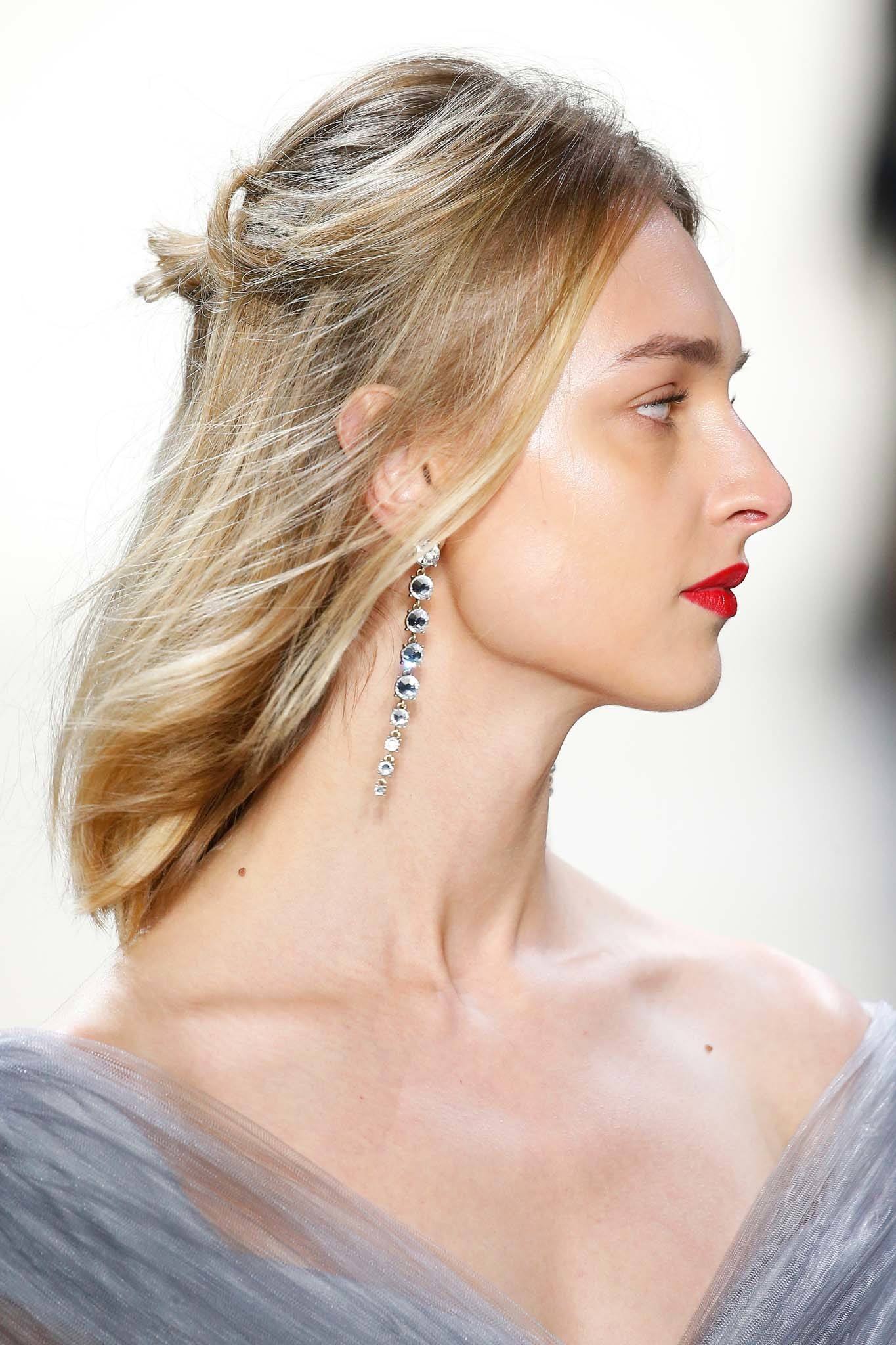 NYFW Catwalk Trends: Model on Tadashi Shoji FW18 runway with shoulder length blonde straight hair in half-up, half-down messy bun wearing red lipstick and diamond drop earrings.