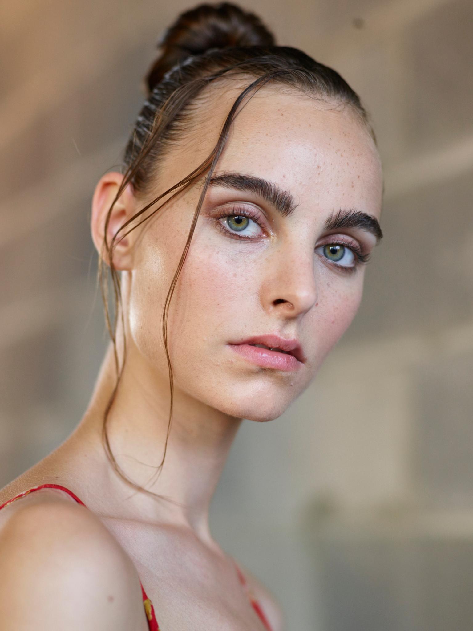 Knot bun hairstyle: Brunette model at Thakoon with a wet look top knot hairstyle