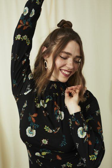 Woman with short wavy brown hair half up bun