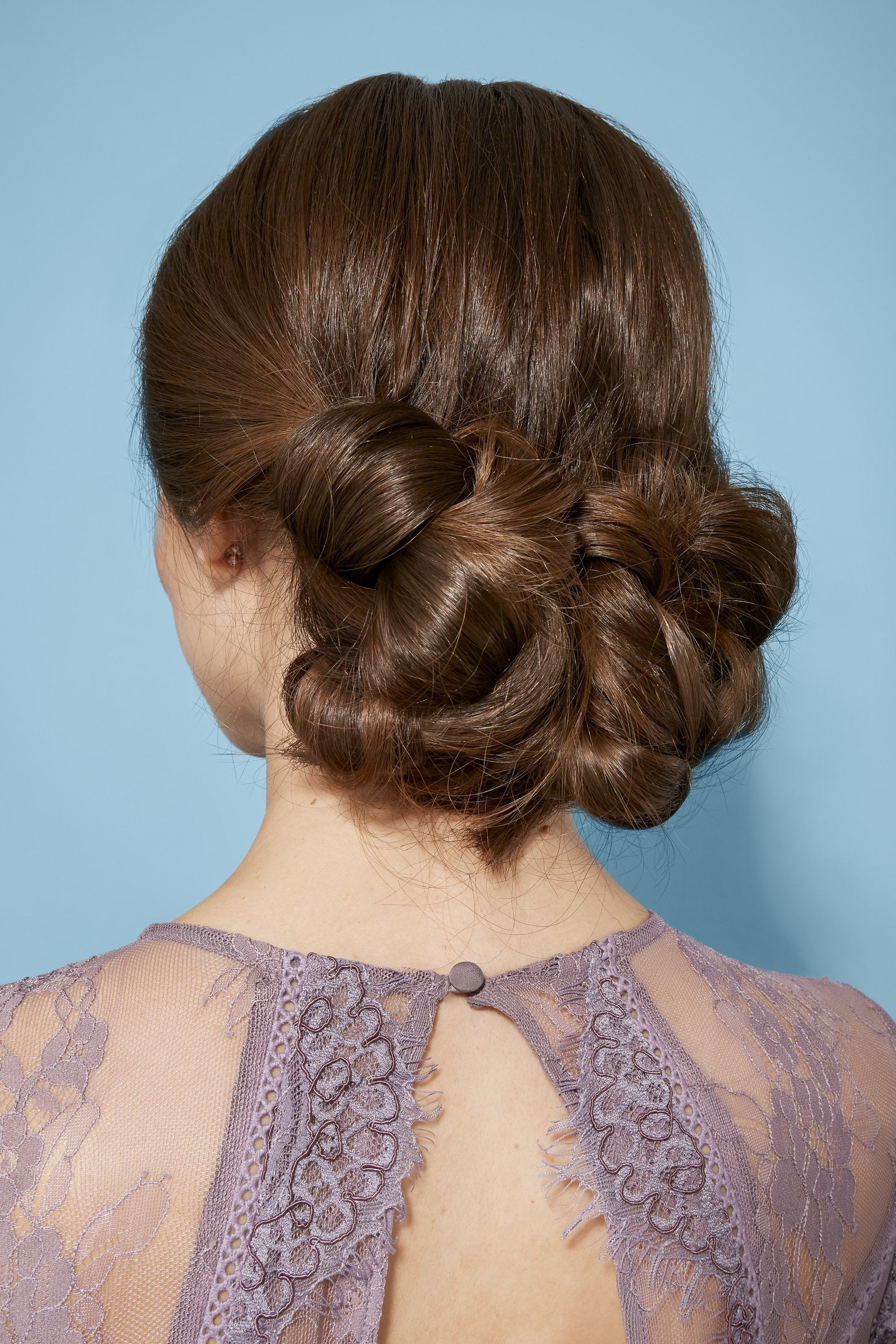 Diwali hairstyles: Close-up back view of a woman with brunette hair in a twisted chignon hairstyle
