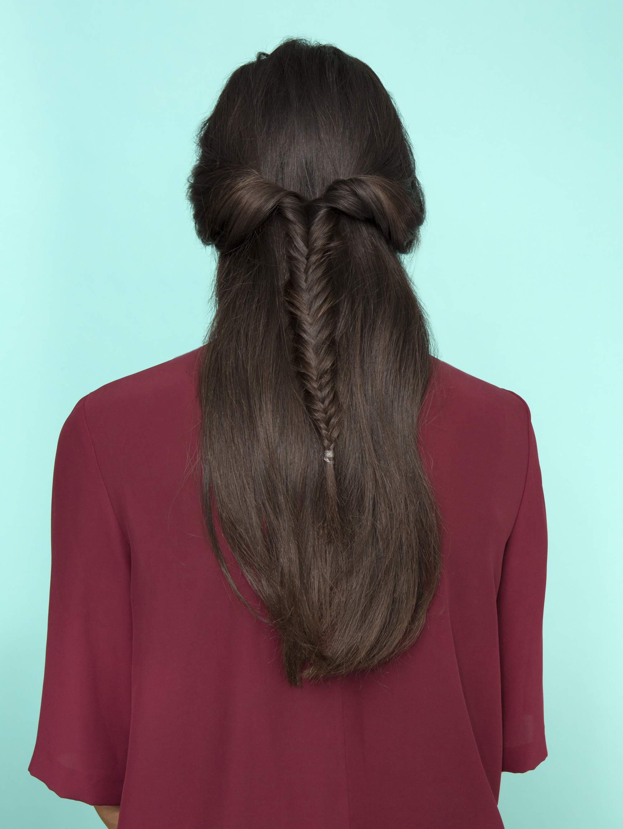 Diwali hairstyles: Back view of a woman with long straight dark brown hair in a half-up fishtail braid