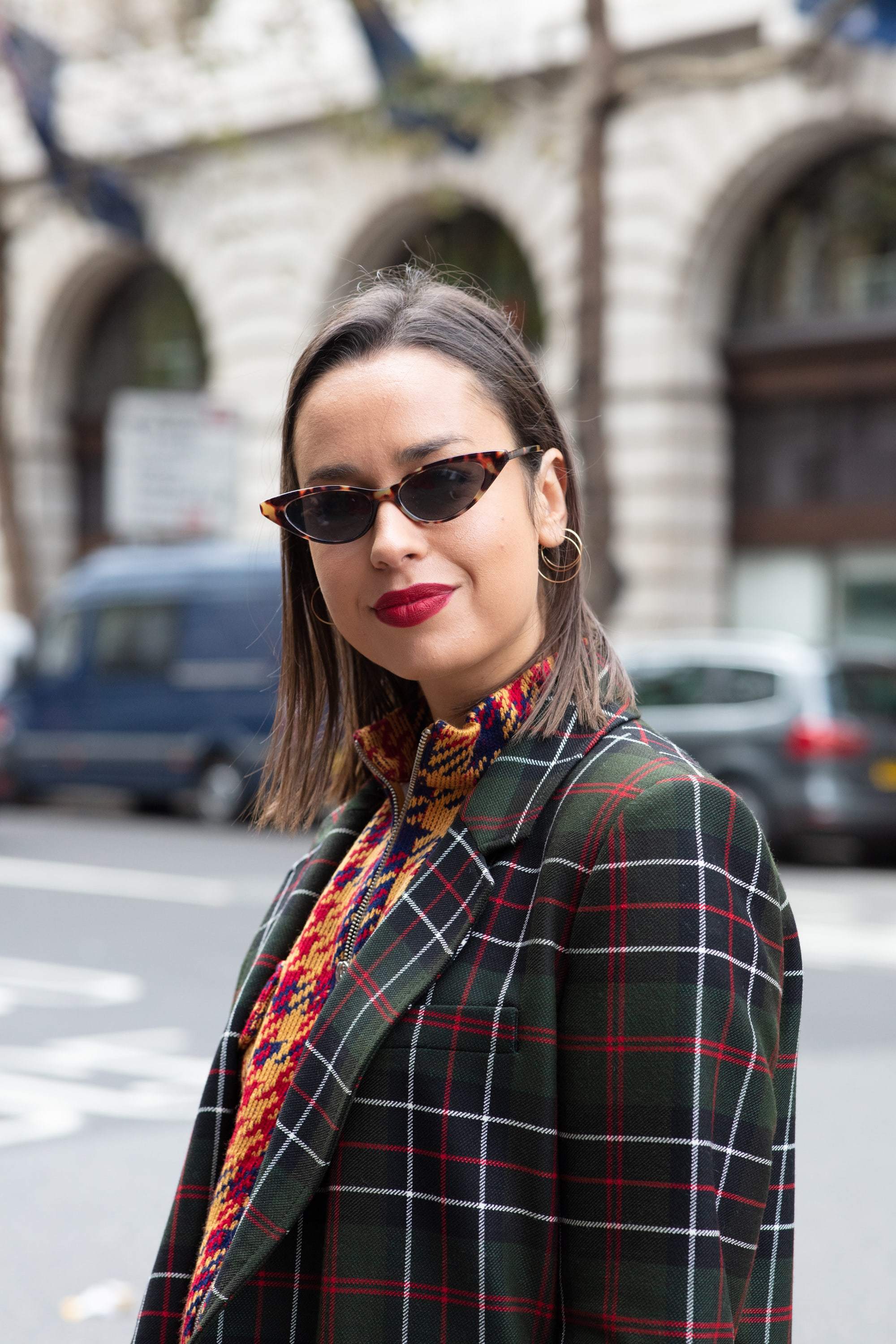 Hair treatment guide: Woman with blunt cut chestnut long bob, wearing checked jacket with tiny glasses