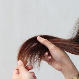 Woman holding her damaged, split hair