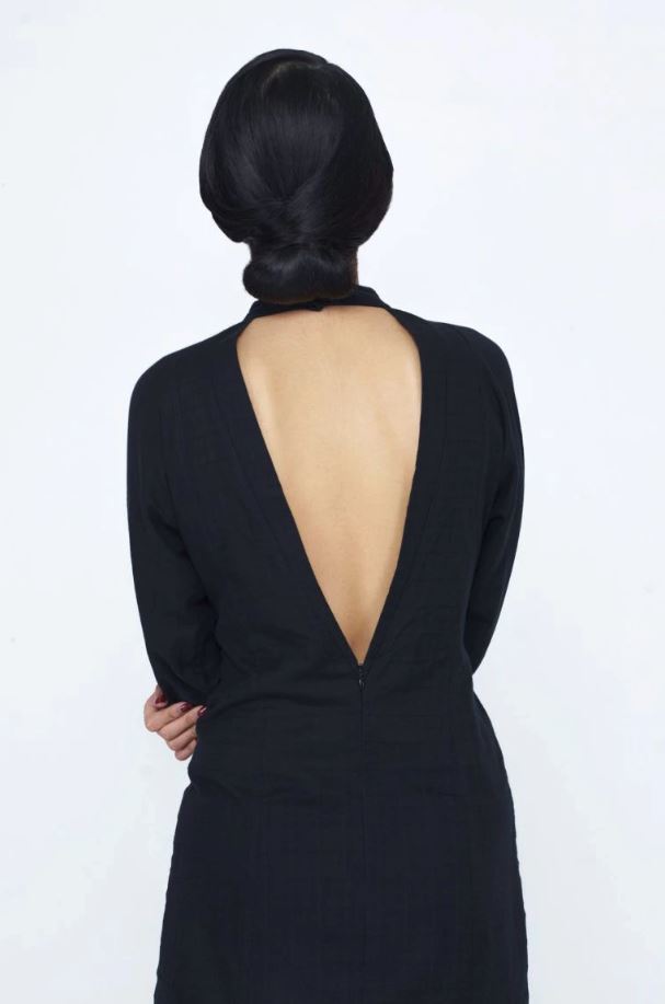 Chinese New Year hairstyles: Woman with straight dark brown hair in a chignon updo wearing a backless dress.