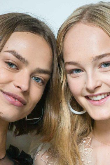 Flexible hold hairspray: Shot of two models with tousled, natural-looking waves, backstage, one with short light brown hair and the other with golden blonde hair