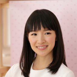 How to Marie Kondo your hair products: Shot of Marie Kondo with her dark medium hair and blunt bangs, wearing a white top and posing against a pink studio background